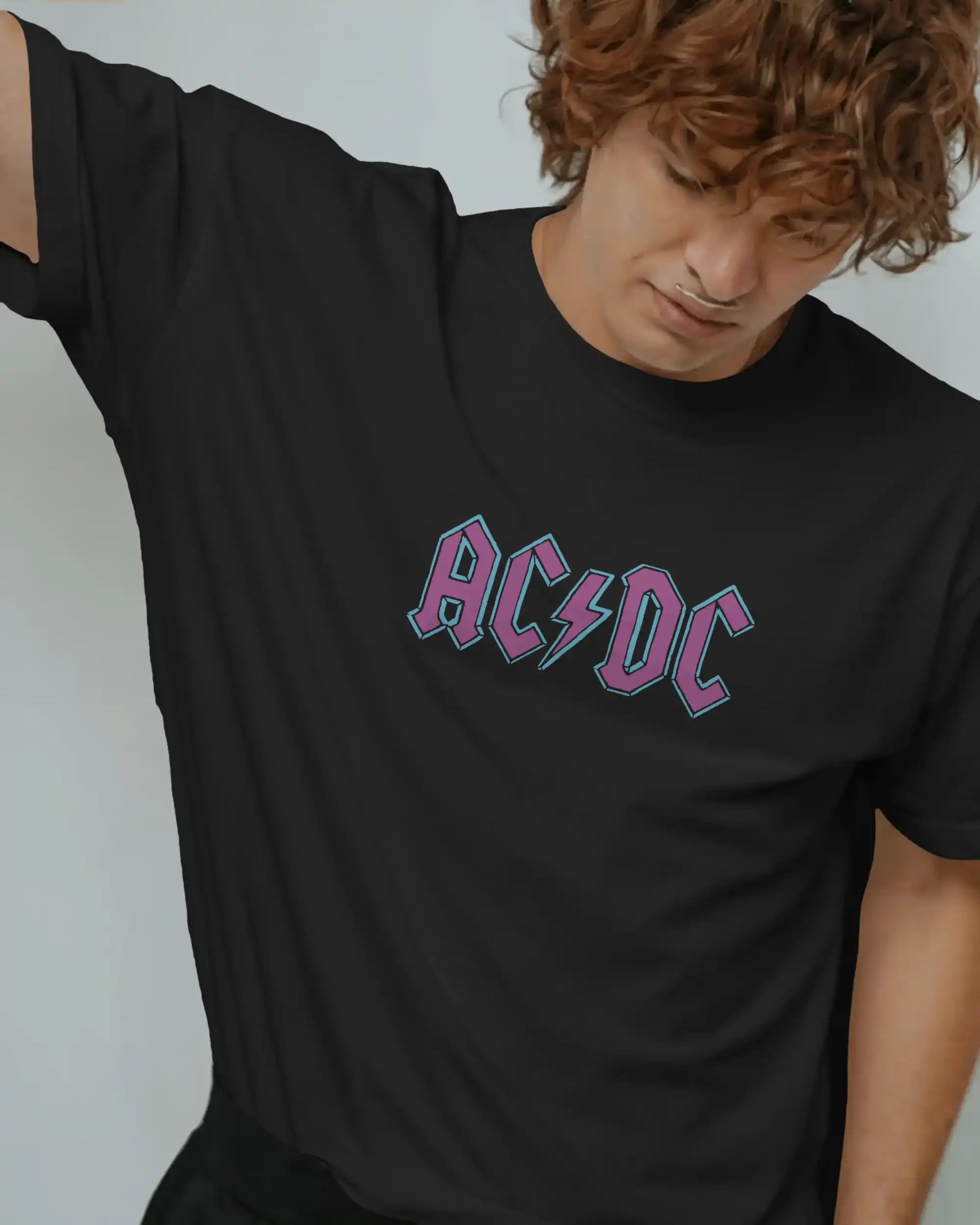 Black plus size oversized t-shirt with AC/DC logo graphic design on front, modeled in a relaxed pose