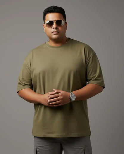 Plus size olive green oversized t-shirt on plus size male model wearing sunglasses, arms crossed front view against gray background, premium AWBlack plain tee