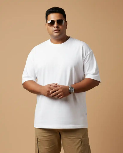 Plus size white oversized t-shirt on plus size male model wearing sunglasses, arms crossed front view against beige background, premium AWBlack plain tee