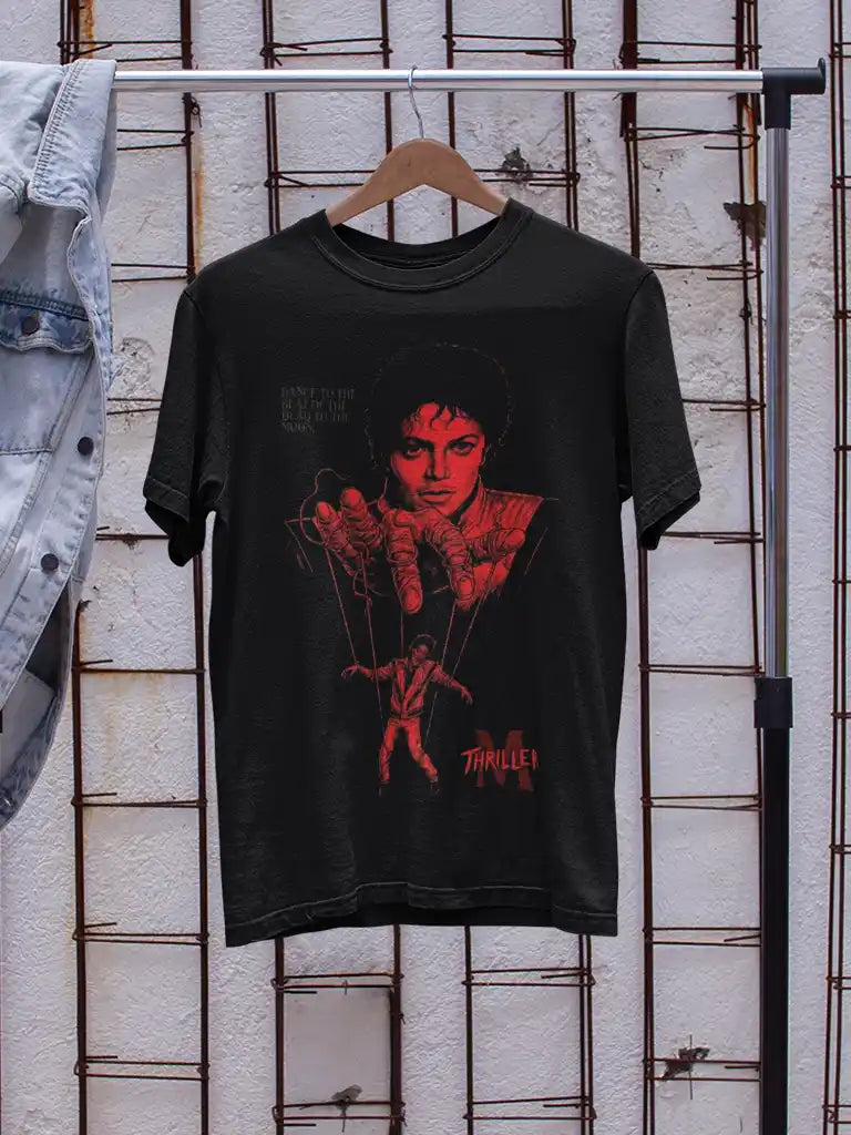 AWBlack Michael Jackson Thriller Vintage Music Puppet Graphic T-Shirt in Black hanging on wooden hanger with denim jacket | Premium 180 GSM Cotton | Multi-Fit Regular, Oversized & Plus Size S–7XL | Red Thriller Print Streetwear Tee for Men | Textured White Wall Background